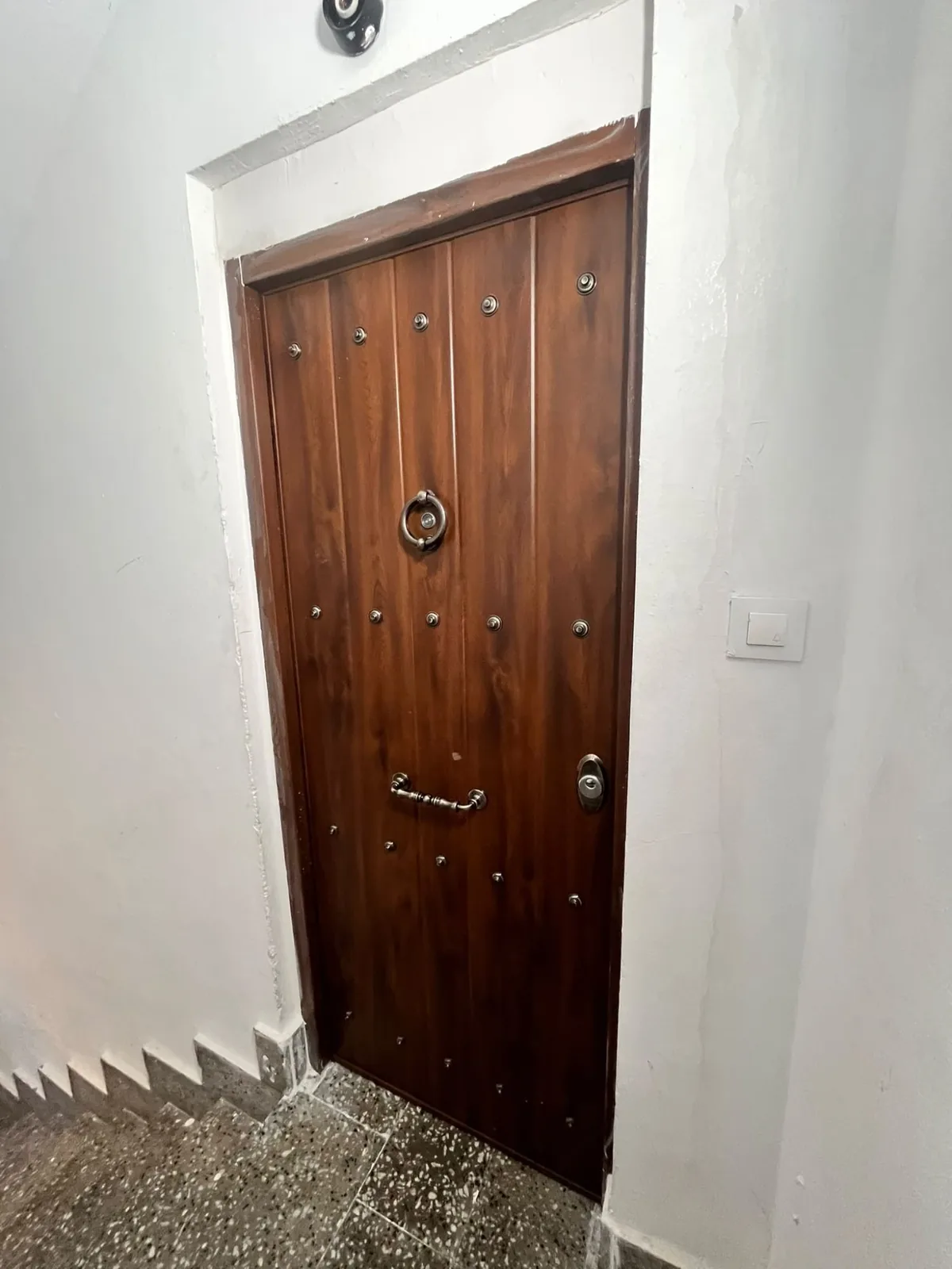 Wooden armoured door fitted on the landing, with the frame finished off